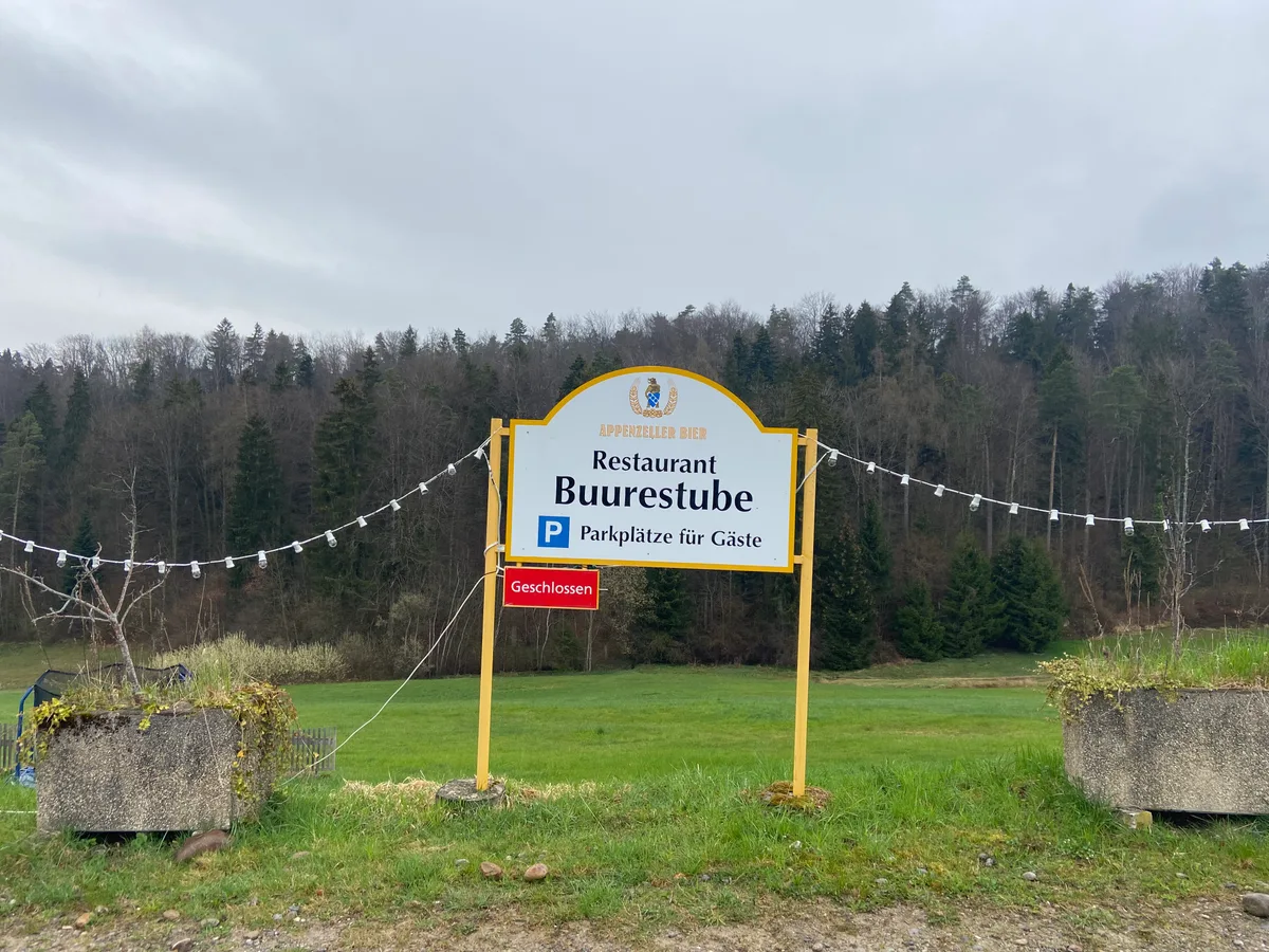 Ein Schild eines Restaurants steht in einer weiten Landschaft.